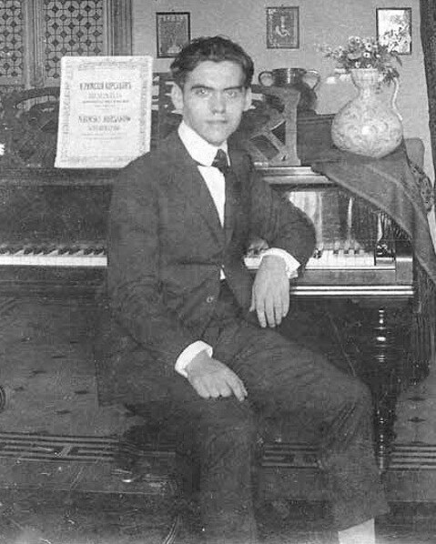 Fotografía de Federico García Lorca junto a un piano.